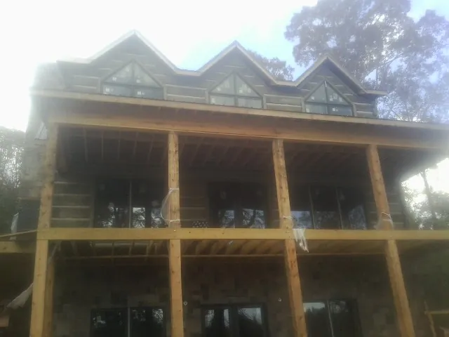Dormers and porch framing on a large log home under construction — Roof Coating work by our crew in Hyattsville