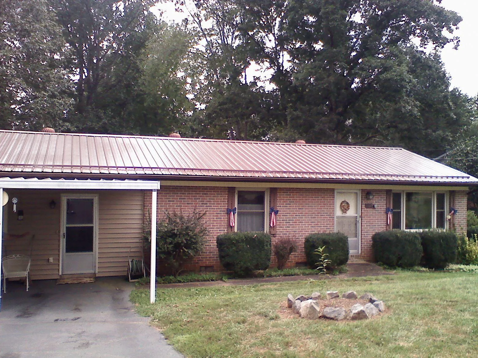 Bronze metal roof and carport on a brick ranch home — Roof Repair work by our crew in Hyattsville