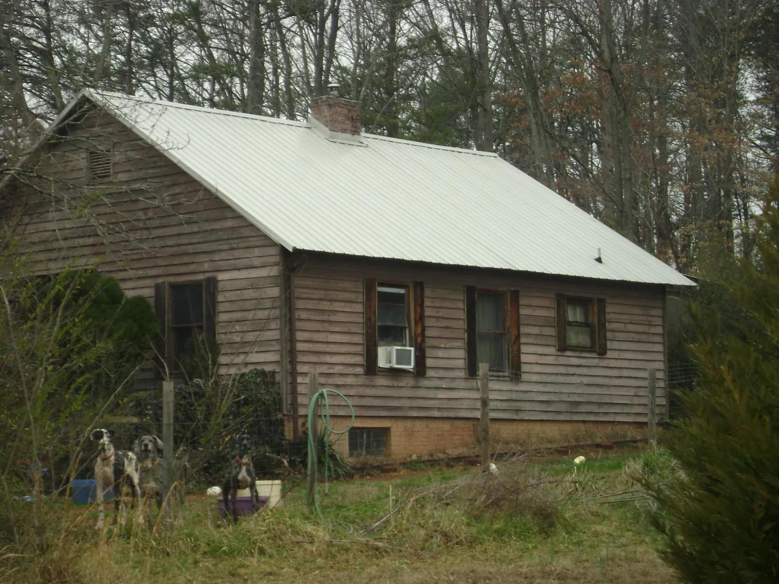 White metal roof on an old wood sided farmhouse, from a Metal Roof Installation job in Hyattsville